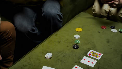 top view of hands of a woman who takes playing cards and poker chips on the table