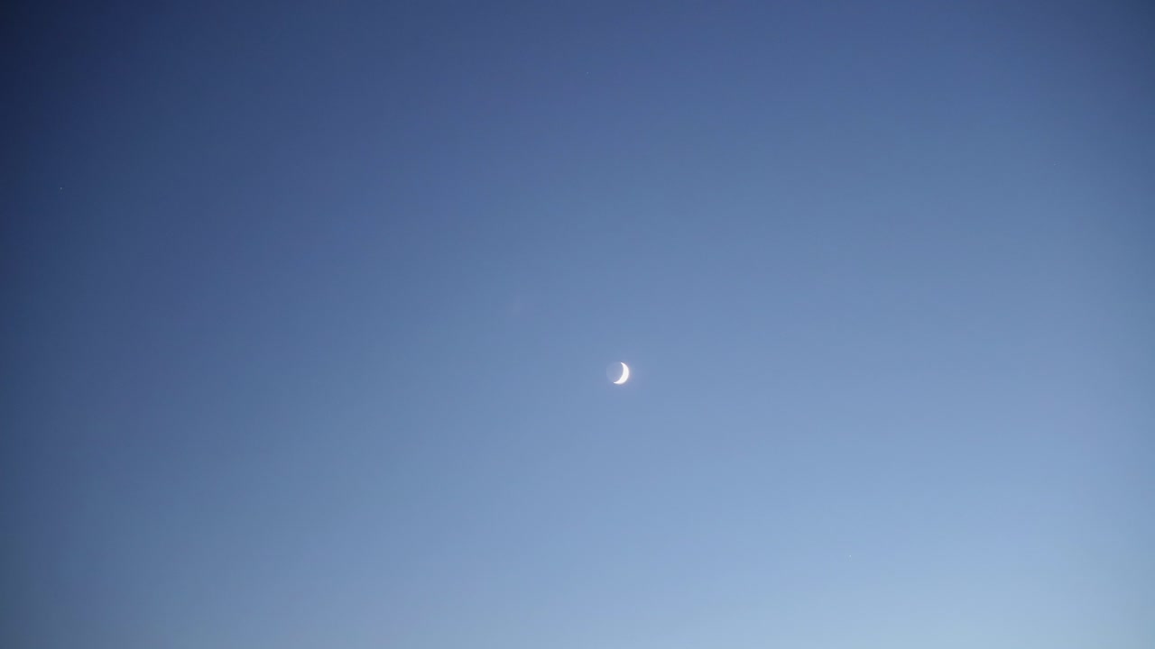 비행기를 건너는 동안 푸른 하늘에 빛나는 달의 초점을 흐리게 하는 흐림
