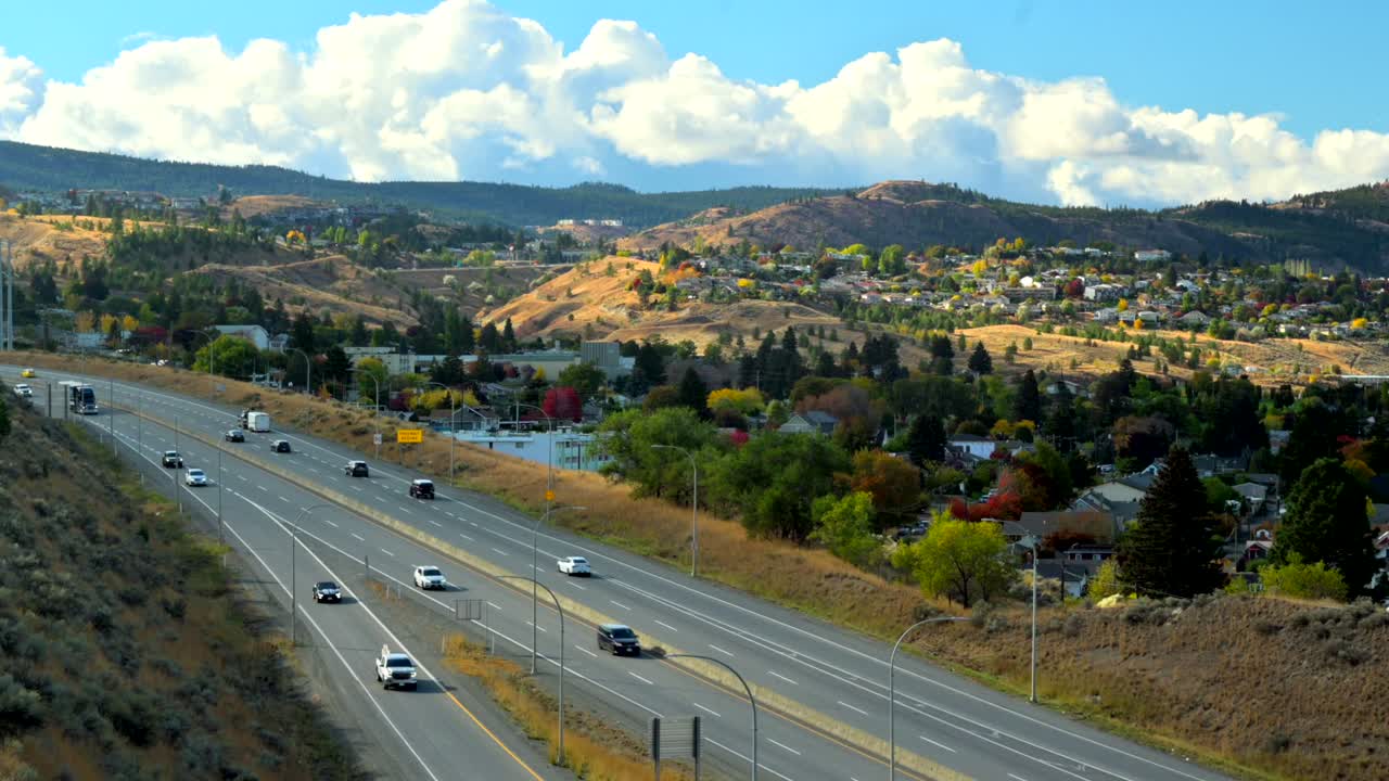 hiperlapso panorámico derecho de la autopista 1 en kamloops bc canadá, con automóviles y camiones conduciendo, la ciudad en el fondo en un ambiente desértico en un día nublado