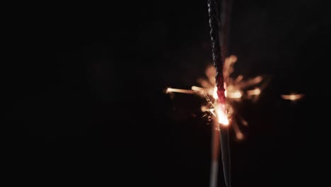 Video-of-close-up-of-sparkler-and-copy-space-on-black-background