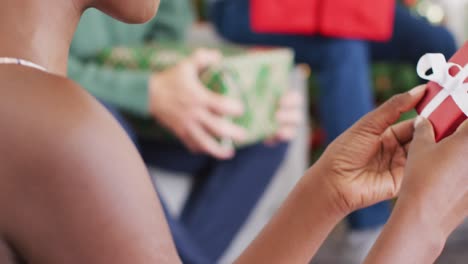 un grupo feliz de amigos diversos abriendo regalos en la fiesta de navidad
