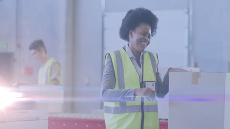 animation of glowing light over african american woman working in warehouse