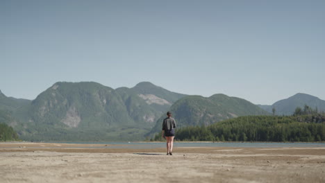 woman walking towards beautiful mountain landscape view with lake