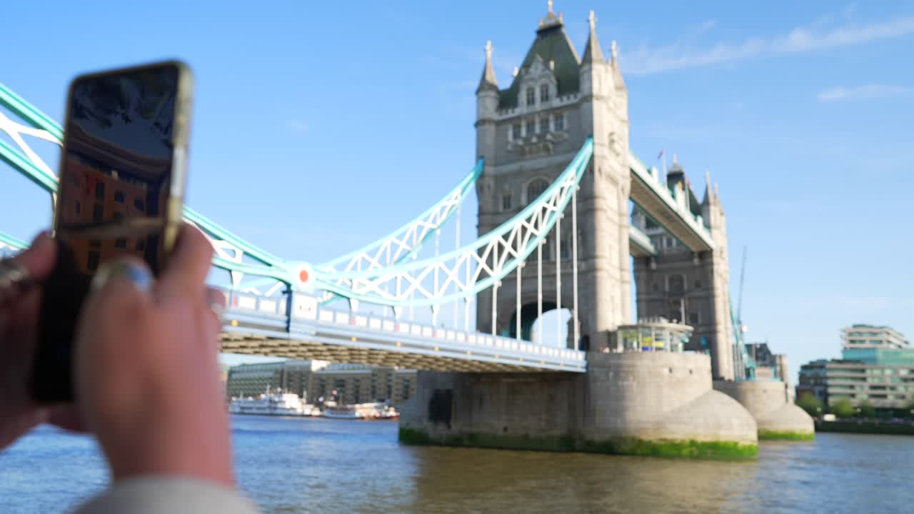 POV: Telefon tar bild av Tower Bridge i London, turistbild, telefonen sänks, fokus skiftar till landmärket.