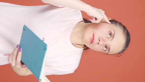 Vertical-video-of-Woman-with-notebook-thinks-and-takes-notes.