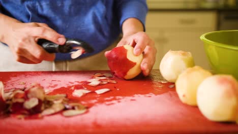 close up hands peeling a peach while baking a pie