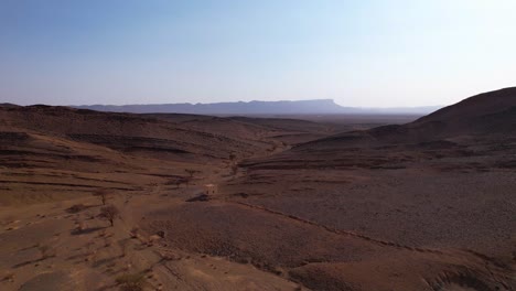 cinematic aerial flight over moroccan sahara desert with sand dunes and dried fields during sunny day in morocco,africa