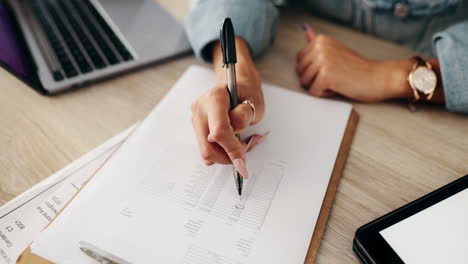 person writing on a clipboard at a desk