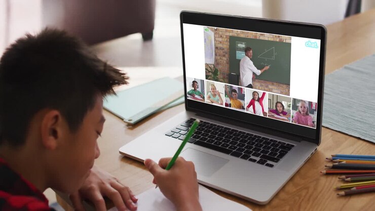 Composito di un ragazzo che usa il laptop per una lezione online a casa, con insegnante e classe diversificate sullo schermo.