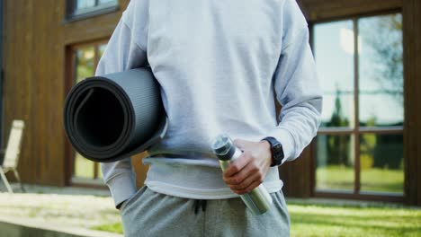 man with yoga mat and water bottle