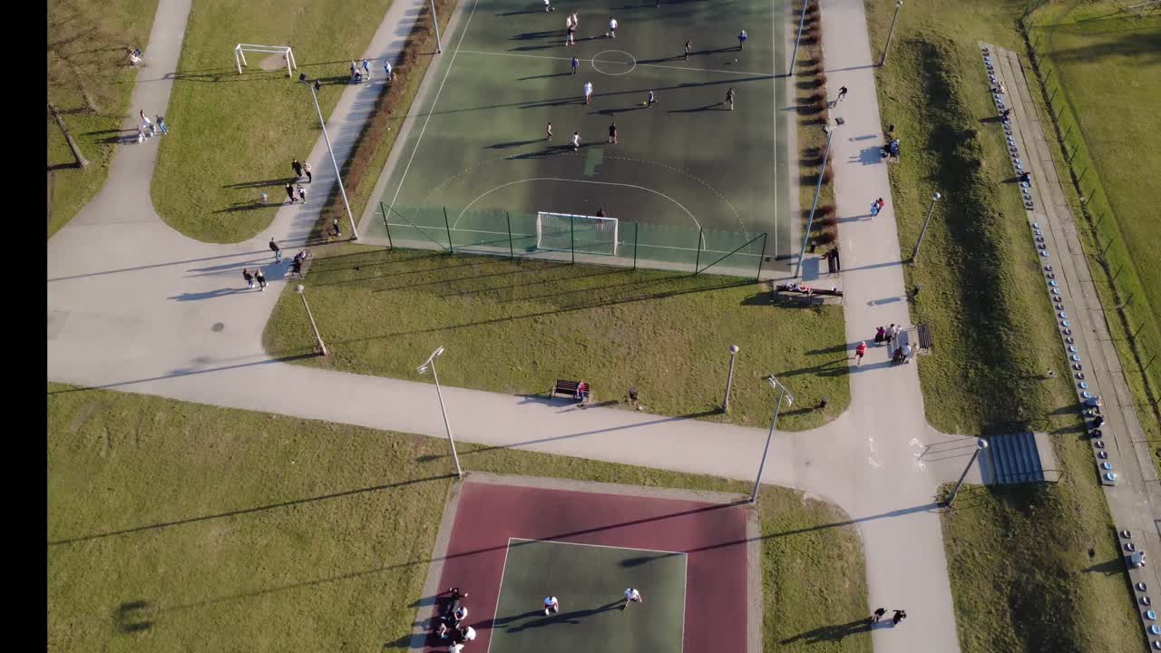 Veduta aerea di persone che giocano su diversi campi sportivi in un parco
