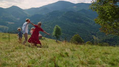 Familia-Jugando-Juegos-Activos-En-La-Montaña-De-Hierba-Verde.-La-Gente-Se-Siente-Feliz.