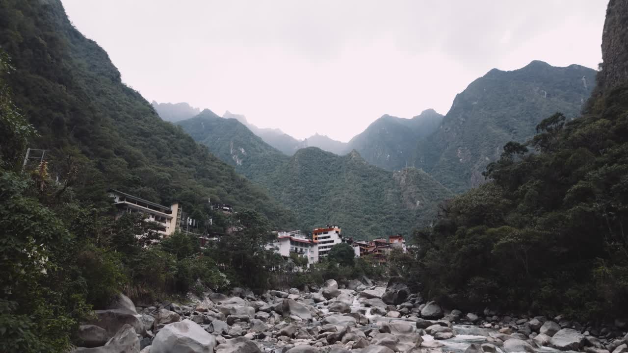 A View of the City With a Jungle Mountain Backdrop, as Seen From the Salkantay Hike in Aguas Calientes, Peru - Pan Up Shot