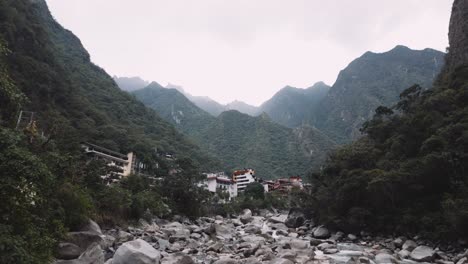 a view of the city with a jungle mountain backdrop, as seen from the salkantay hike in aguas calientes, peru - pan up shot