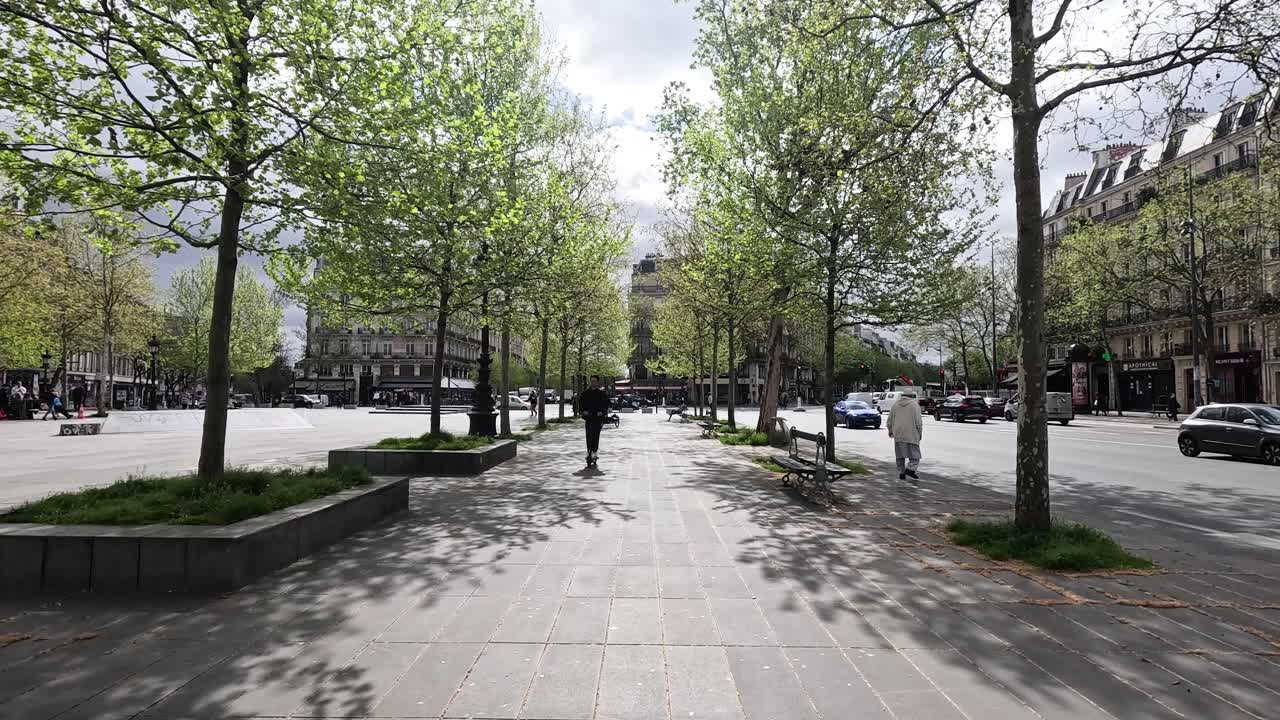 Una persona attraversa una piazza del parco cittadino