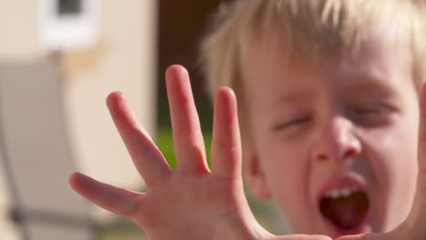 a cute little boy holding his fingers up, slow motion