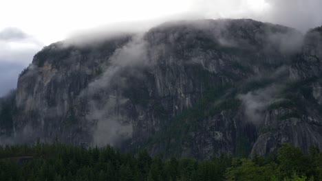 stawamus chief mountain through fog clouds in british columbia, canada