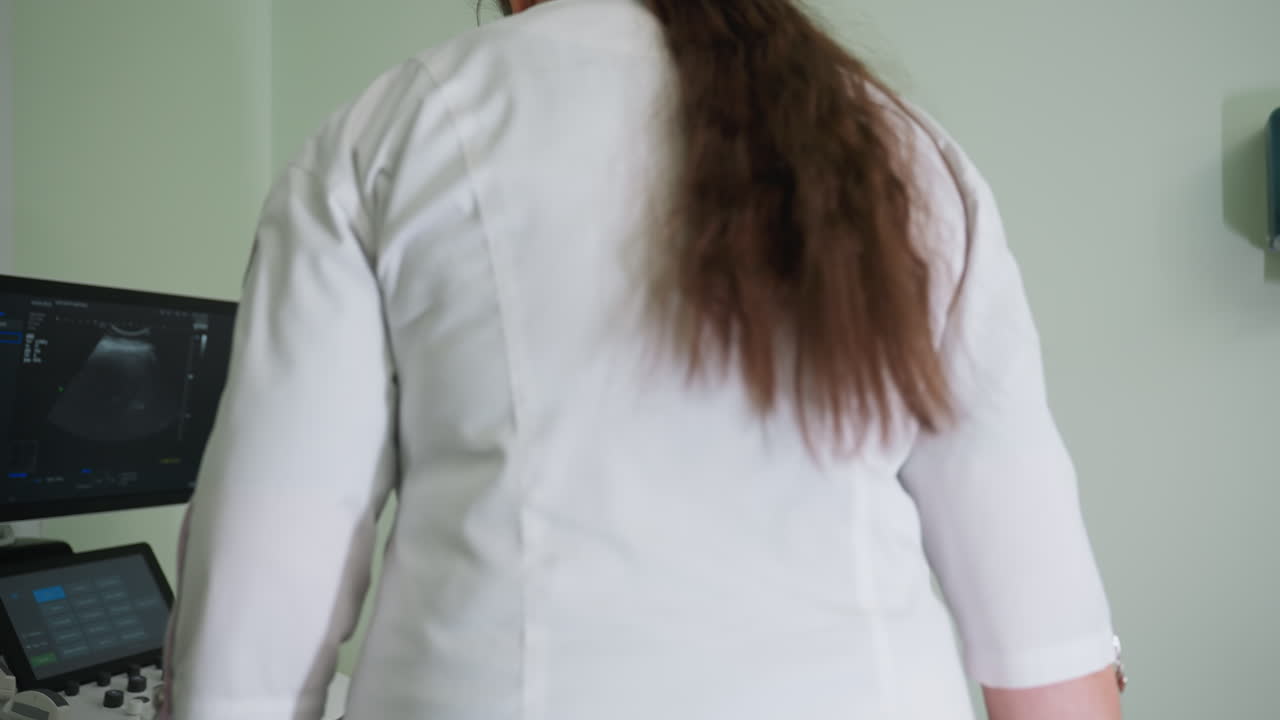Female lab scientist prepares to examine young boy lying on medical bed using ultrasound equipment in clinical lab setting with focus on diagnostic accuracy and professional healthcare routine