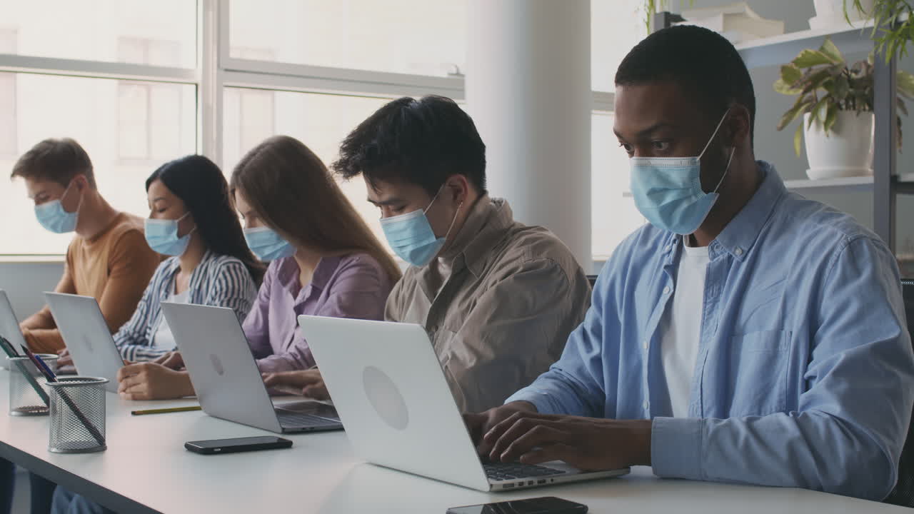 전염병 기간 동안 사무실에서 일하는 다양한 그룹의 사람들이 마스크를 착용합니다.