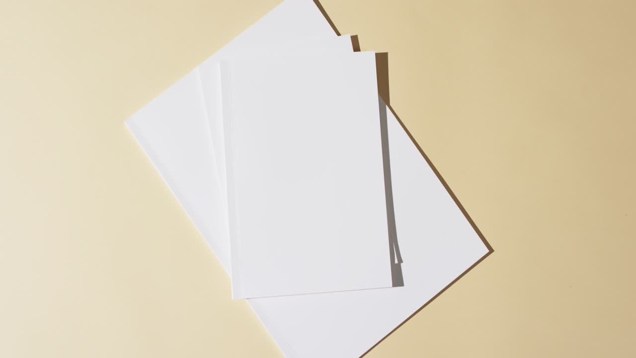 Video of books with blank white pages and copy space on yellow background