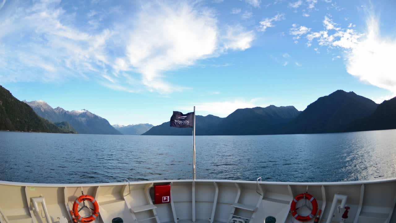 Časosběr z pohledu přídě lodi vplouvající do fjordu Parque Pumalin před úsvitem poblíž Puerto Montt v Chile.
