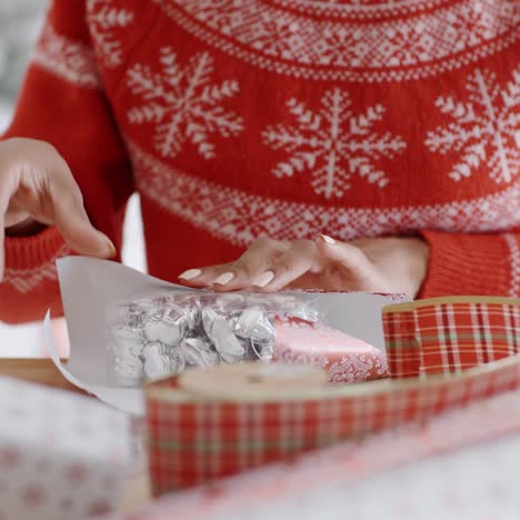 Young-woman-carefully-wrapping-a-Christmas-gift