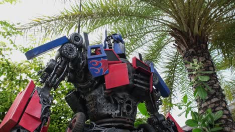 camera zooms out showing these metal scraps wielded together to create a transformer version outside a restaurant in bangkok, thailand