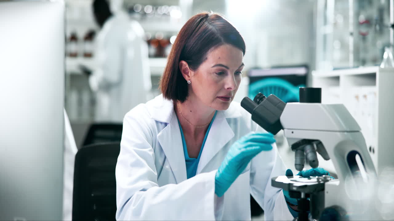 Scienziato che usa il microscopio in laboratorio