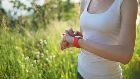 woman checking fitness smartwatch in a field