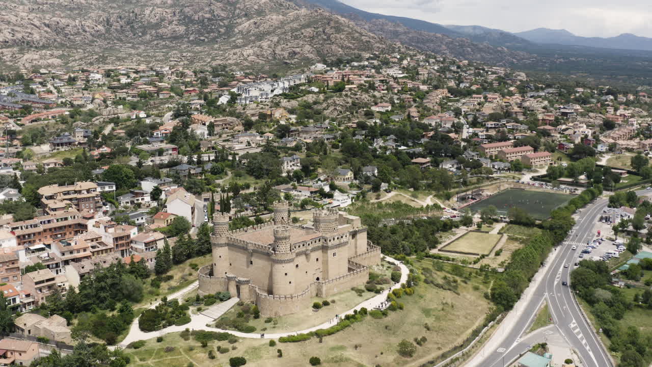 Ampia veduta aerea in allontanamento del Castello di Mendoza e dei paesaggi circostanti di Manzanares El Real, Spagna.