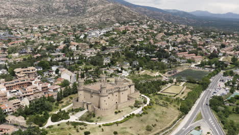 wide aerial pull out view over the castle mendoza and the surrounding landscapes of manzanares el real spain