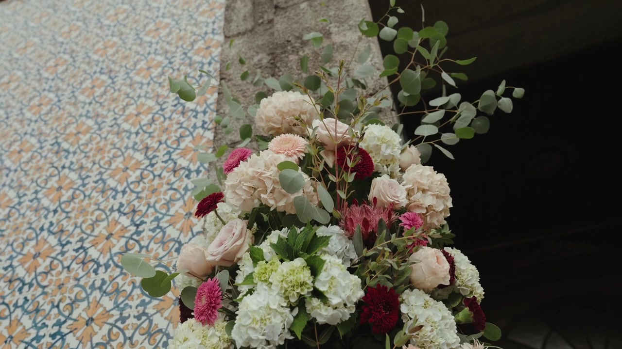 Elegante composizione floreale da sposa con rose rosa, ortensie bianche e foglie di eucalipto, per una decorazione bellissima