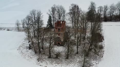 aerial view of old abandoned church tower ruins, snowy winter landscape