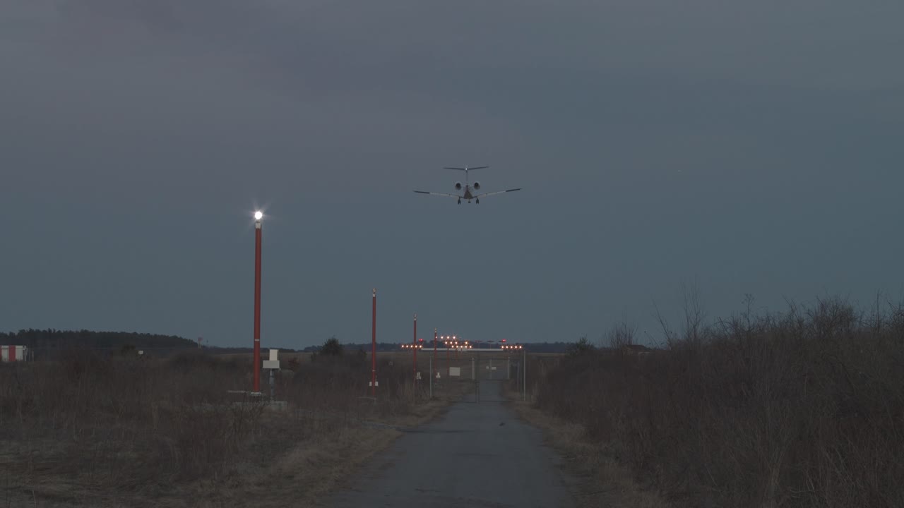 활주로 끝에서 본 황혼에 제트기가 착륙합니다.