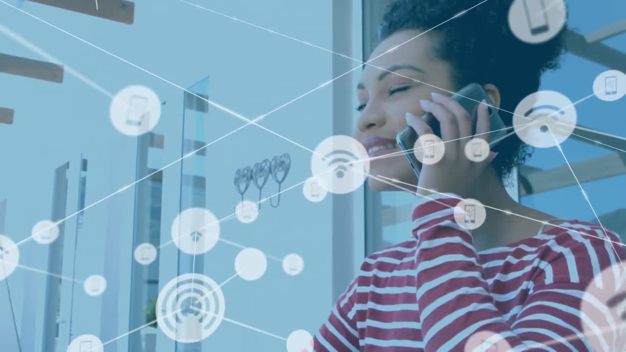 animación de una red de iconos digitales sobre una feliz mujer afroamericana hablando en un teléfono inteligente