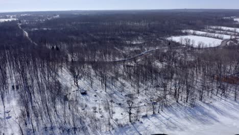 Drone-moving-laterally-over-a-large-park-in-winter