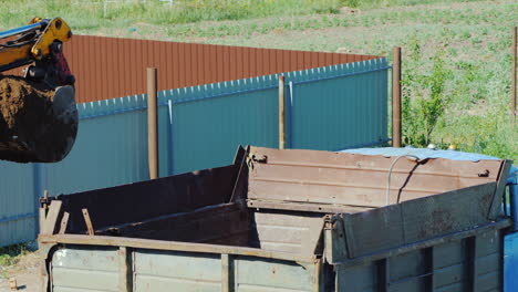 Excavator-Bucket-Pours-Ground-Into-The-Truck