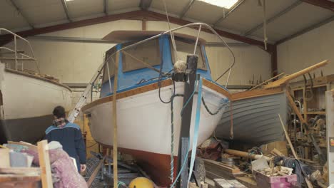 young apprentice shipwright boards fiberglass boat to inspect gunwale