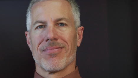 um close de um homem sorrindo ao lado de sua coleção de livros