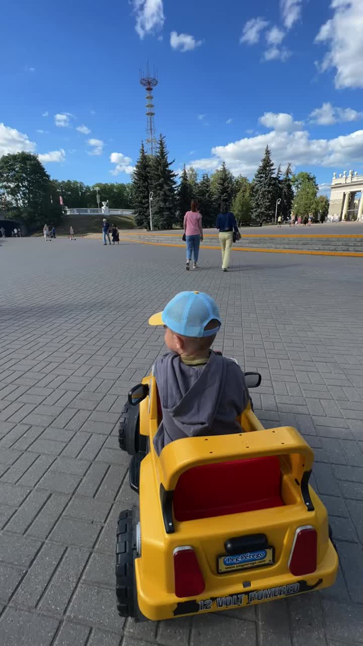 Child driving toy car in urban area