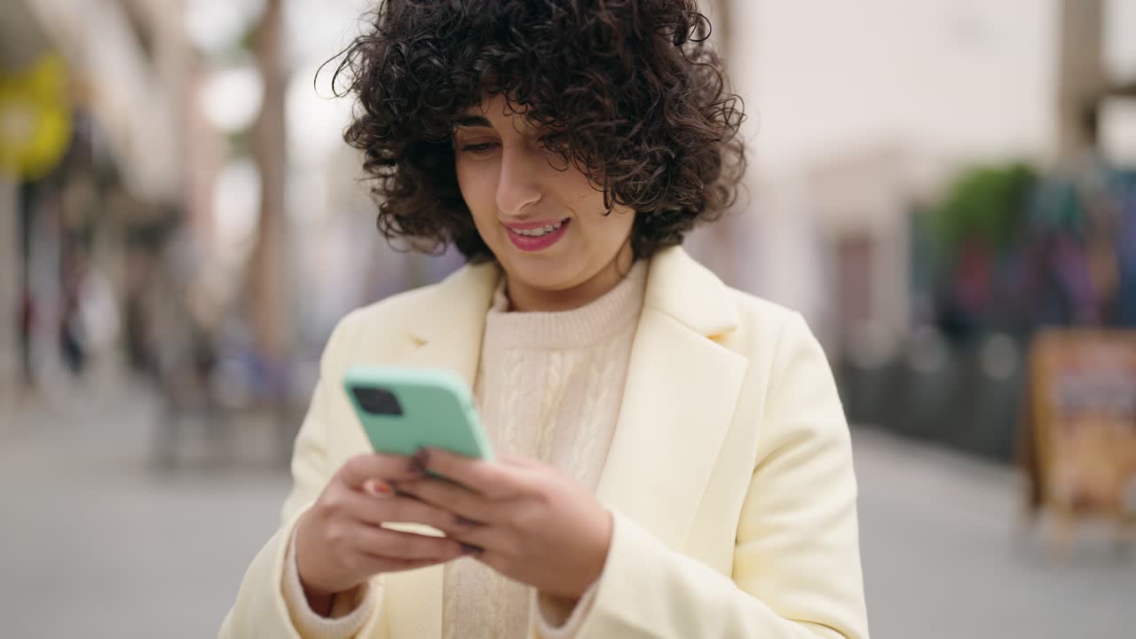 Young woman smiling confident using smartphone at street