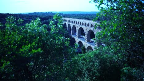 historic stone arch bridge made of sandstone over a gorge in france by the romans in the middle of nature