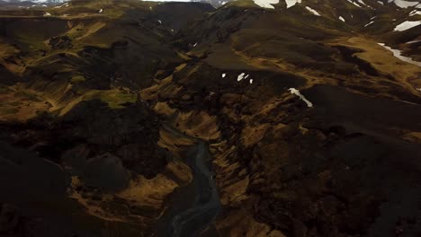 aerial landscape view of a river flowing through iceland highlands and volcanic black sand