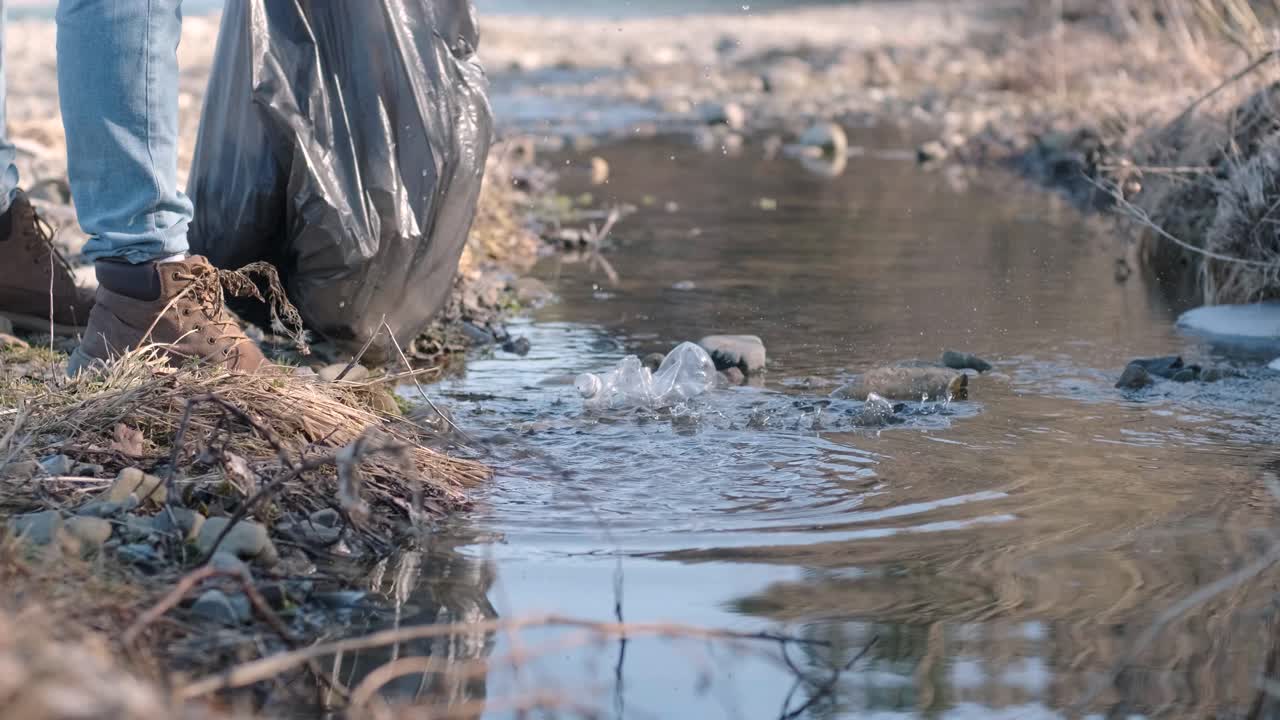 ビーチでプラスチックを清掃するチームワーク。ボランティアがゴミ袋にゴミを集めている。プラスチック汚染と環境問題のコンセプト。プラスチックから自然を自主的に清掃する。地球の緑化