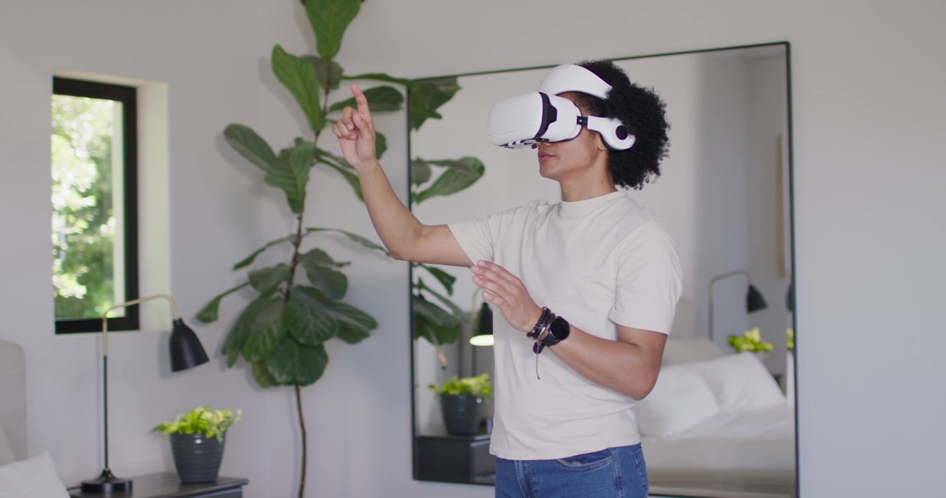 Uomo afroamericano che gesticola con un visore VR in camera da letto, con un menu che appare, selezionando elementi UI.