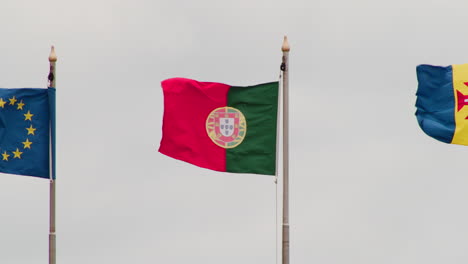 portuguese flag waving in the wind against sky - low angle shot