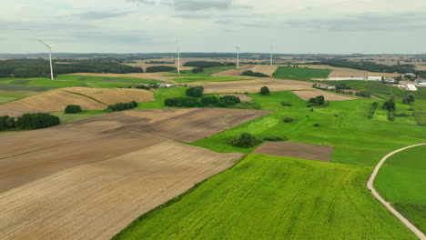 panoramic view of rolling farmlands with wind turbines in the distance