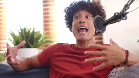 talking passionately, young man gesturing with hands while recording podcast at home
