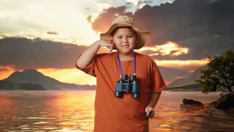 asian boy with a hat and binoculars using the magnifying glass then making call me gesture at a lake. boy researcher examines something, travel tourism adventure concept