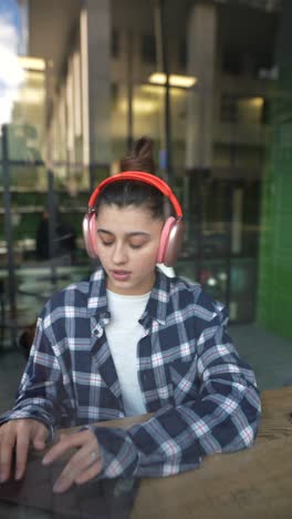 mujer joven trabajando en una computadora portátil en un café